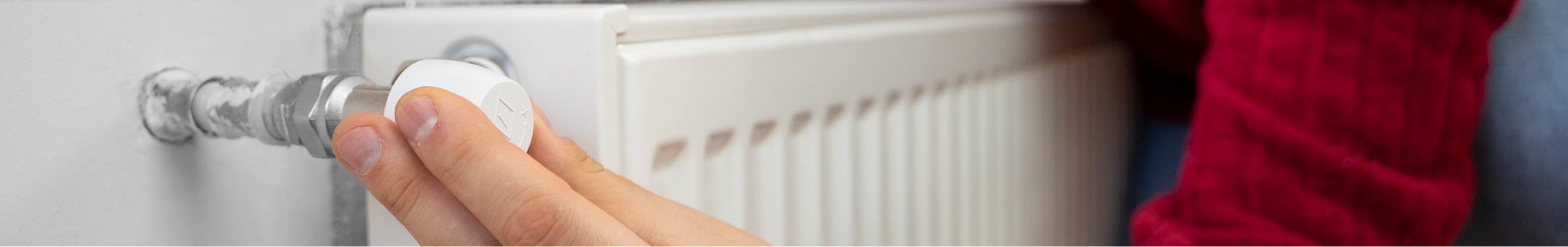 Hand stellt das Thermostatventil einer Heizung ein – Wissenswertes rund um Heizöl von mein heizöl (Lang Energie AG)
